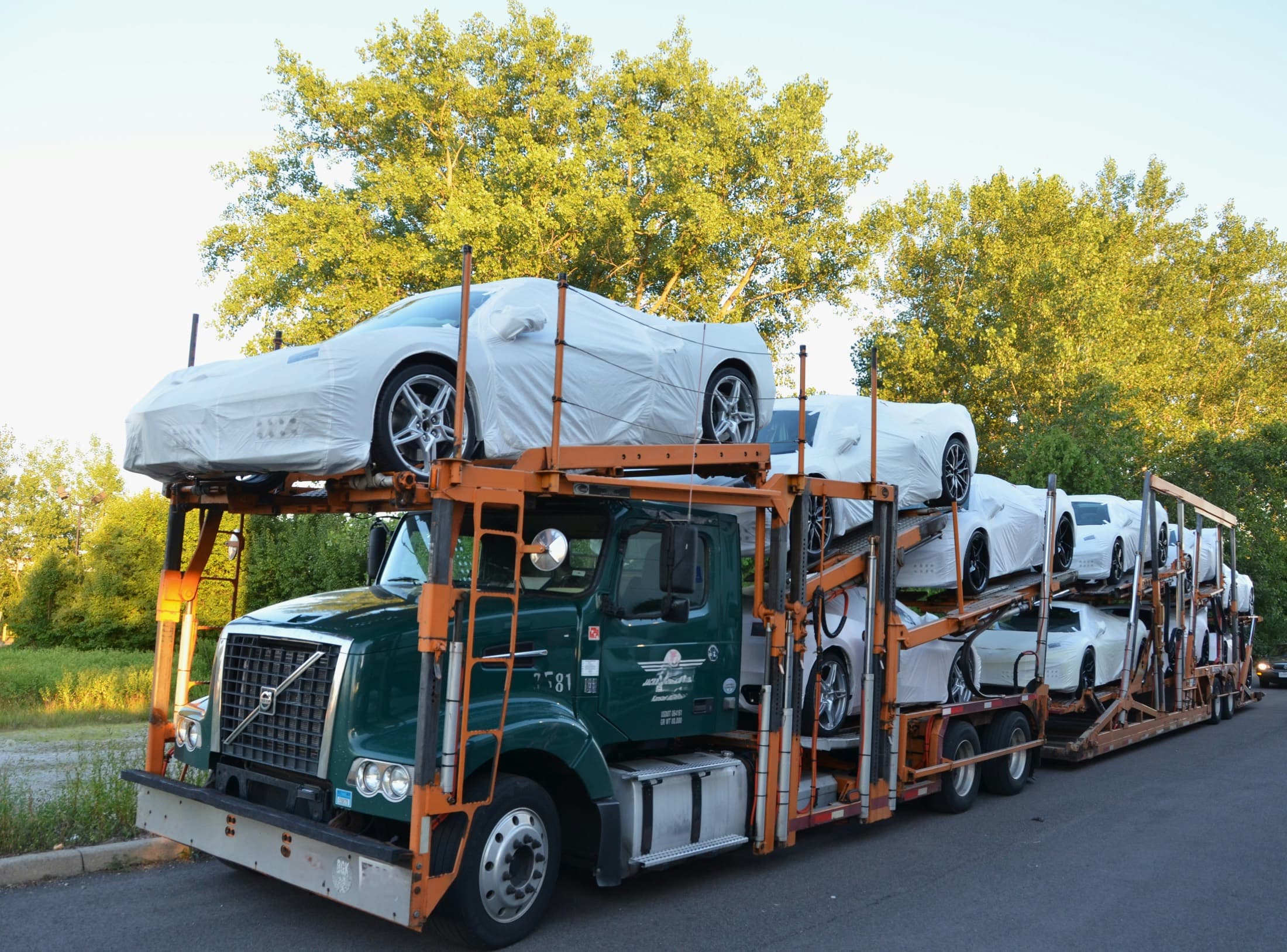 Vehicles secured on an open multi-car transport trailer