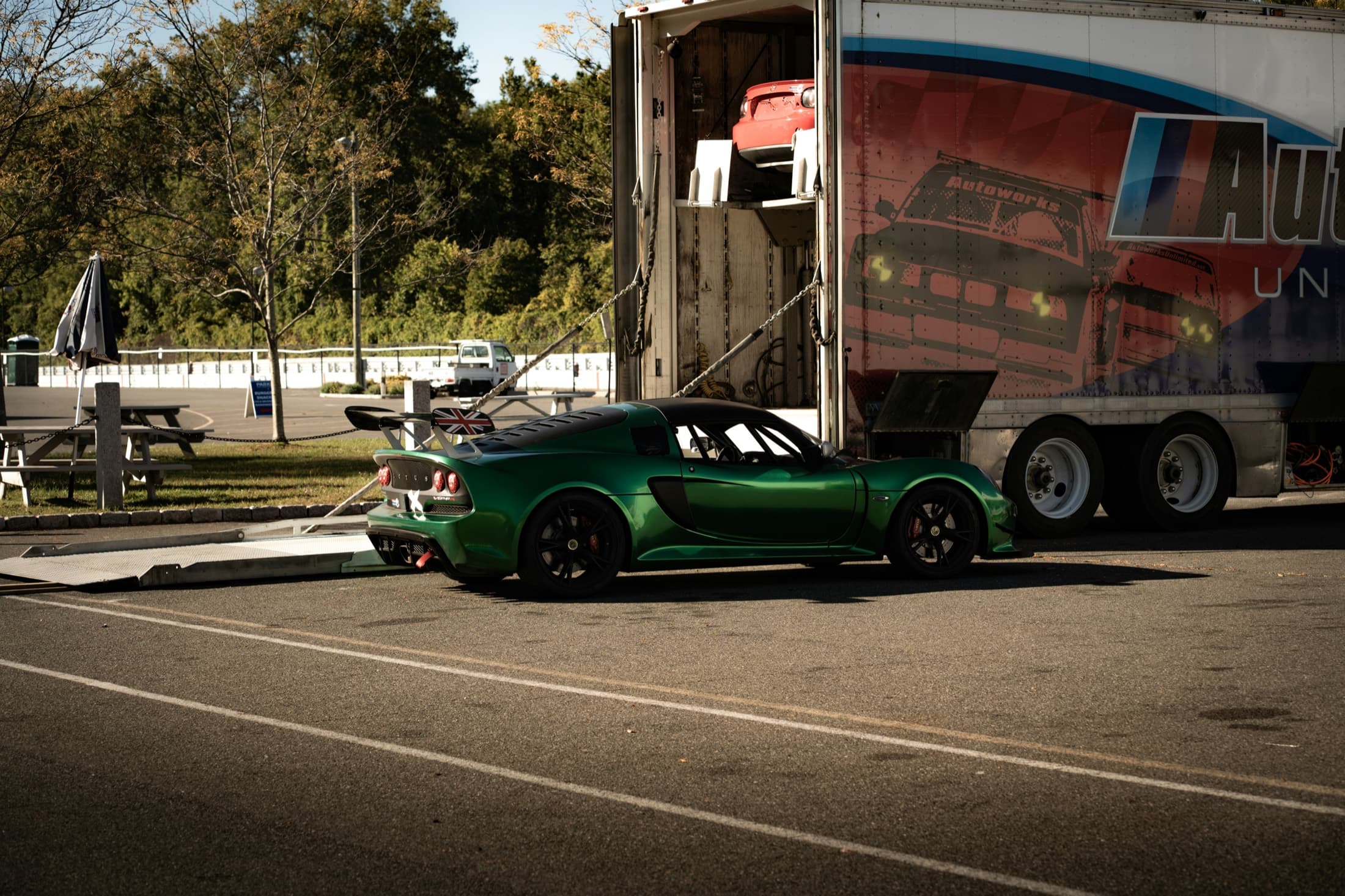 A sports car being loaded up a ramp into a transport trailer
